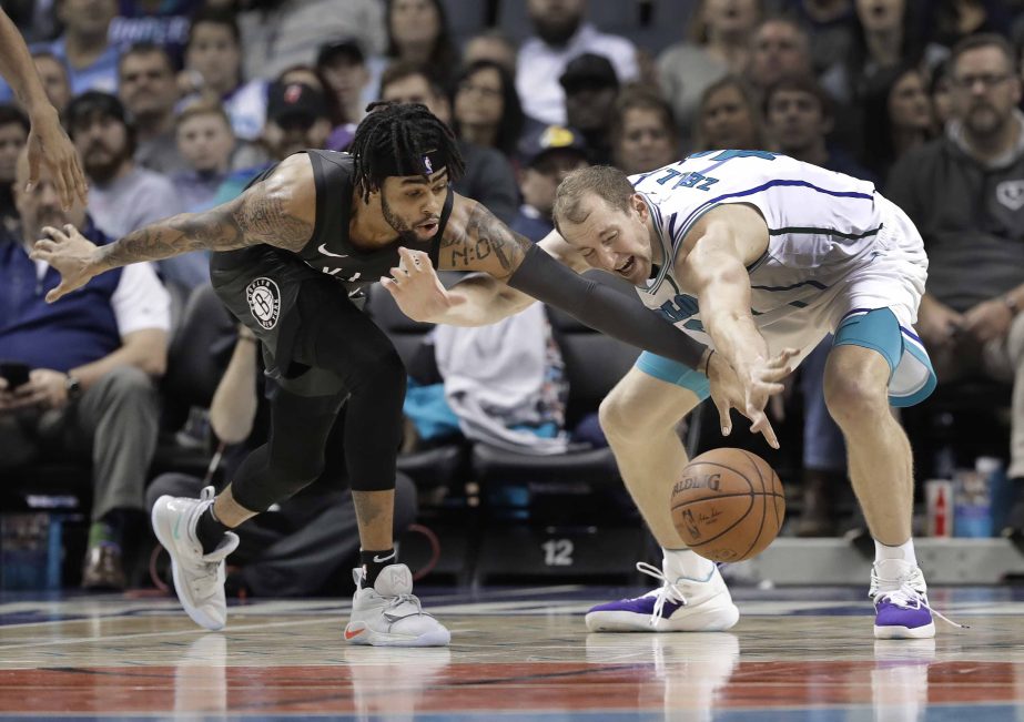 Charlotte Hornets' Cody Zeller (right) and Brooklyn Nets' D'Angelo Russell (left) chase a the ball during the second half of an NBA basketball game in Charlotte, N.C. on Friday.