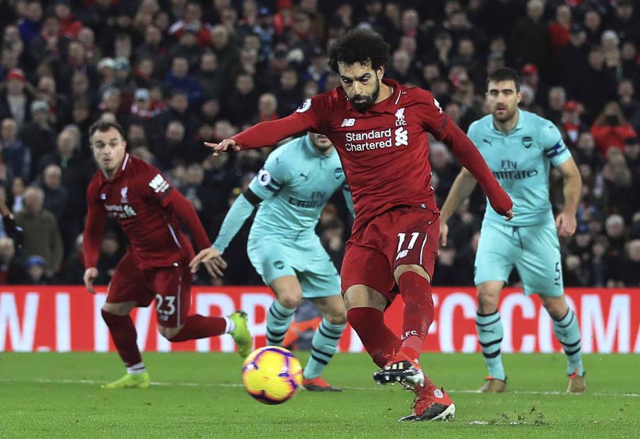 Liverpool's Mohamed Salah scores his side's fourth goal of the game against Arsenal, during their English Premier League soccer match at Anfield Stadium in Liverpool, England on Saturday.