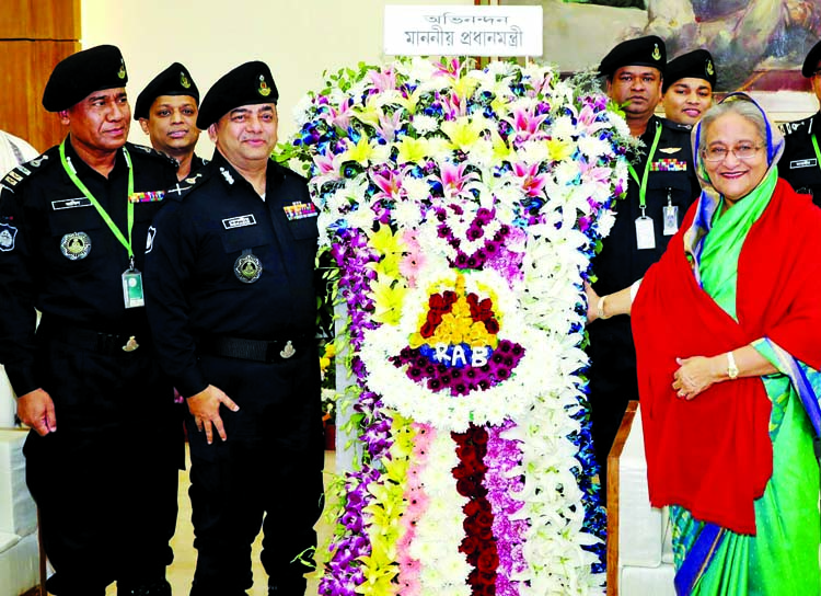 RAB members led by its Director General Benazir Ahmed paying floral tributes to Prime Minister and Awami League President Sheikh Hasina at Ganobhaban on Monday for her party's landslide victory in the 11th parliamentary elections.