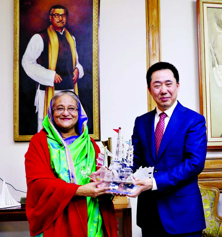 Chinese Ambassador in Dhaka Zhang Zuo handing over replica of 'Boat' to Prime Minister and Awami League President Sheikh Hasina at Ganobhaban on Monday for her party's landslide victory in the 11th parliamentary elections. BSS photo