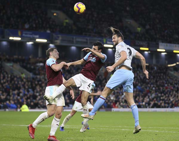 West Ham United's Andy Carroll (right) heads towards the Burnley goal in action during their English Premier League soccer match at Turf Moor in Burnley, England on Sunday.