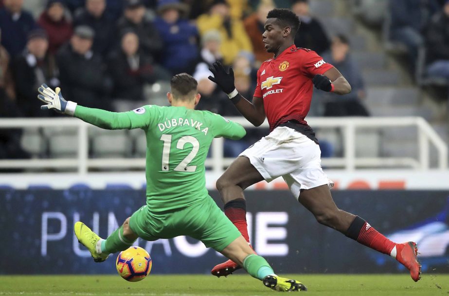 Manchester United's Paul Pogba (right) dribbles past Newcastle United goalkeeper Martin Dubravka during a Premier League soccer match at St James' Park on Wednesday in Newcastle, England.