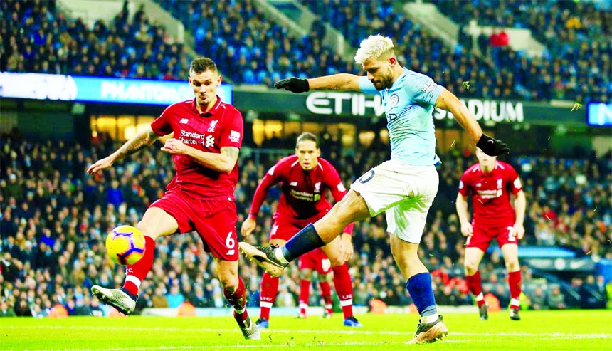 Manchester City's Sergio Aguero (right) shoots and scores the opening goal of the game during their English Premier League soccer match between Manchester City and Liverpool at the Ethiad stadium, Manchester, England on Thursday.