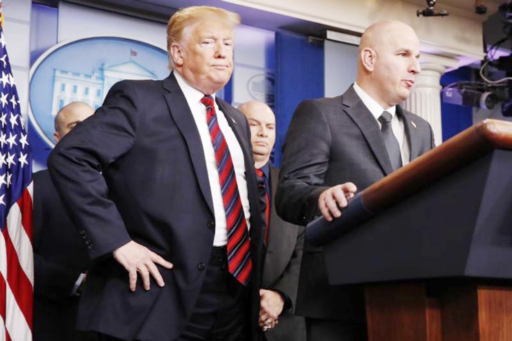 President Donald Trump, left, listens as Brandon Judd, President of the National Border Patrol Council, talks about border security on Thursday, after making a surprise visit to the press briefing room of the White House in Washington.