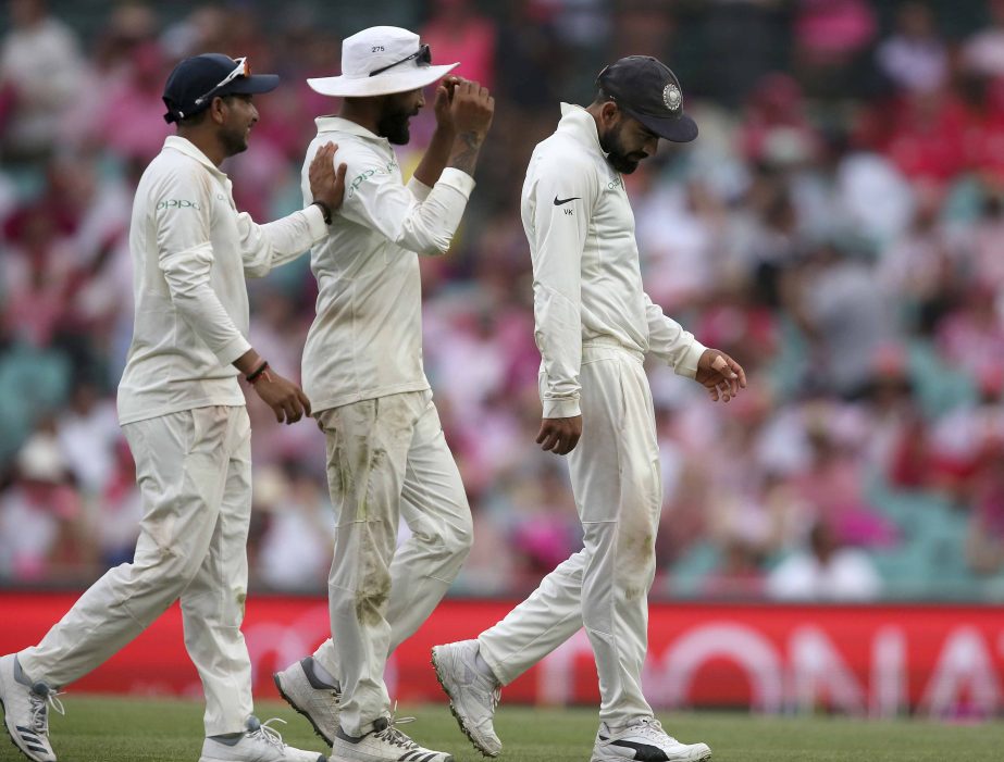 India's Virhat Kohli (left) Kuldeep Yadav (right) and Ravindra Jadeja walk off after the umpires called a halt to play as the light fades and a storm threatens on day 3 of their cricket Test match against Australia in Sydney on Saturday.