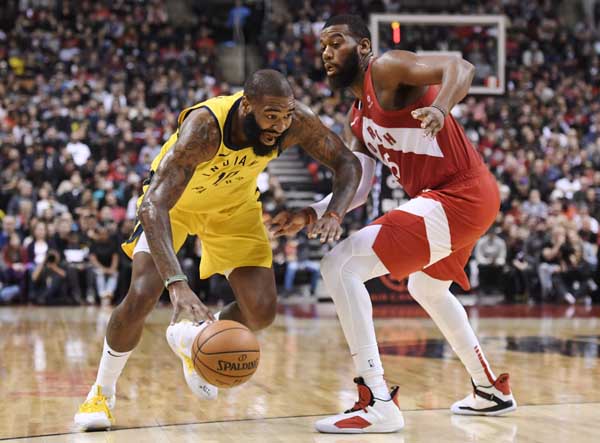Indiana Pacers centre Kyle O'Quinn (10) drives past Toronto Raptors centre Greg Monroe (15) during second half NBA basketball action in Toronto on Sunday.