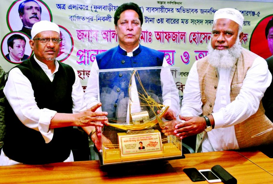 President of Dhaka Trade Center South Shop Owners Association Alhaj Humayun Kabir Molla handing over a crest to Alhaj Afzal Hossain for his election as MP for the third consecutive term from Kishoreganj-5 constituency. The snap was taken from Dhaka Trade