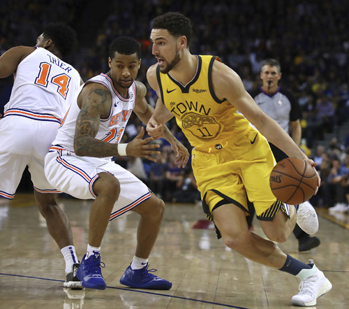 Golden State Warriors' Klay Thompson (right) drives as New York Knicks' Trey Burke (23) defends during the second half of an NBA basketball game in Oakland, Calif on Tuesday.