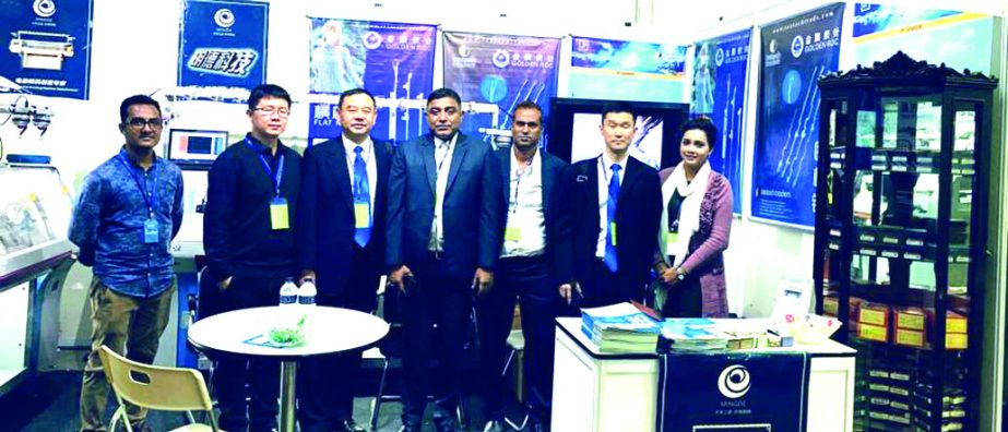 Visitors poses for a photograph after visiting the Textile Traders stall at 16th Dhaka International Textile and Garment Machinery Exhibition at International Convention City, Bashundhara on Thursday.