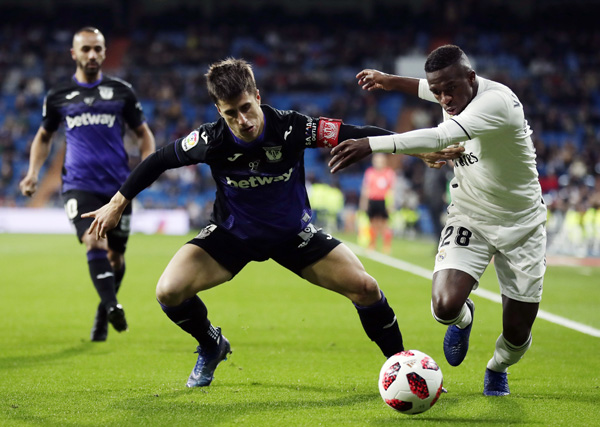 Real Madrid's Vinicius Jr (right) duels for the ball with Leganes' Unai Bustinza during a Spanish Copa del Rey soccer match between Real Madrid and Leganes at the Bernabeu stadium in Madrid, Spain on Wednesday.