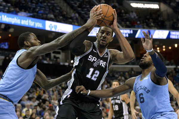 San Antonio Spurs forward LaMarcus Aldridge (12) controls the ball between Memphis Grizzlies forward JaMychal Green (left) and guard Shelvin Mack during the second half of an NBA basketball game in Memphis, Tenn on Wednesday.