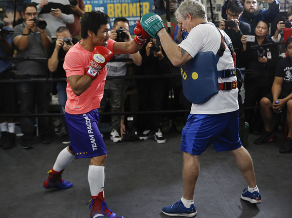 Manny Pacquiao (left) works out with trainer Freddie Roach at a boxing club in Los Angeles on Wednesday. Pacquiao is scheduled to defend his WBA welterweight title against Adrien Broner on in Las Vegas.
