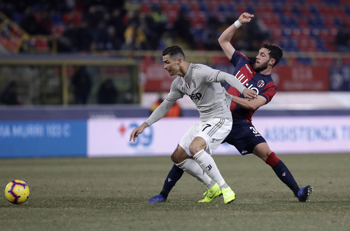 Juventus' Cristiano Ronaldo (left) challenges for the ball with Bologna's Arturo Calabresi during a round of 16 Italian Cup soccer match between Bologna and Juventus at the Renato Dall'Ara stadium in Bologna, Italy on Saturday.