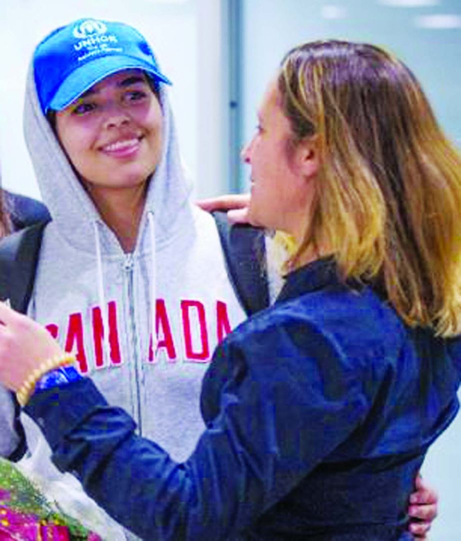 Saudi teenager Rahaf Mohammed al-Qunun (centre, blue cap) is welcomed by Canadian Minister for Foreign Affairs Chrystia Freeland Â® as she arrives at Pearson International airport in Toronto, Ontario.