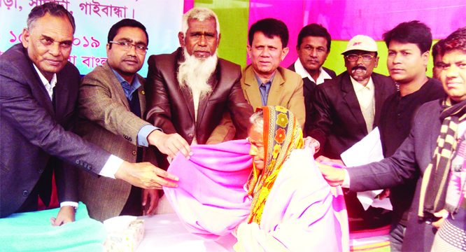 SAGHATA (Gaibandha): Uzzal Kumar Gosh, UNO, Saghata Upazila distributing blankets among the cold-hit people at Char Gobindapur Dakhil Madrasa in Haldia Union recently.