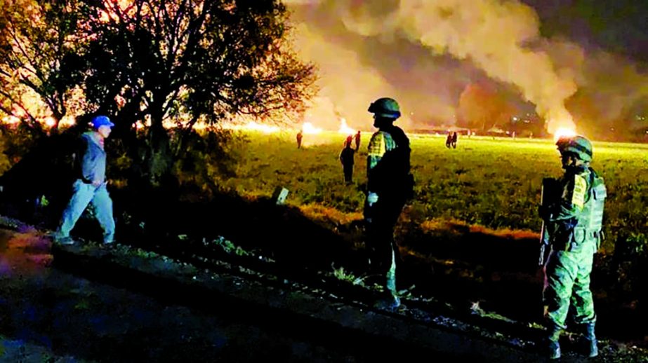 Military personnel watch as flames engulf an area after a ruptured fuel pipeline exploded, in the municipality of Tlahuelilpan, Hidalgo, Mexico, near the Tula refinery of state oil firm Petroleos Mexicanos (Pemex). Internet photo