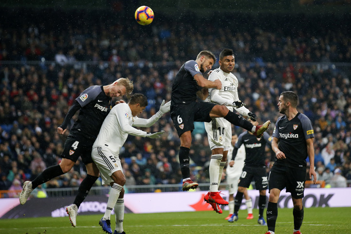 Real Madrid and Sevilla players try to head the ball during the La Liga soccer match between Real Madrid and Sevilla at the Bernabeu stadium in Madrid, Spain on Saturday.