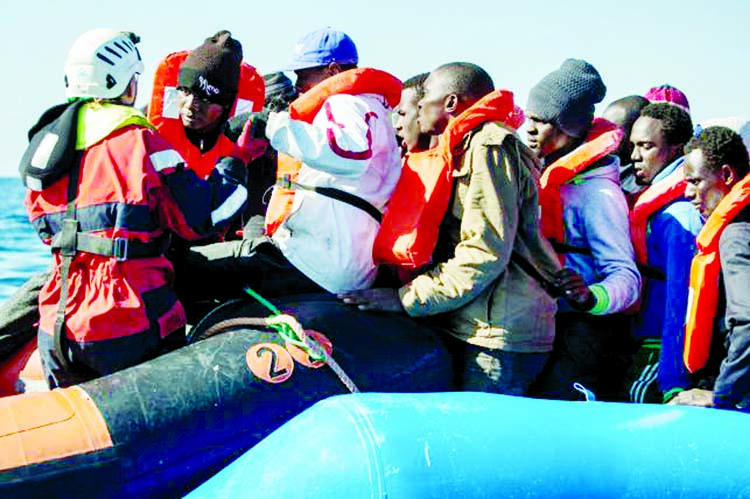 A group of 47 migrants is helped by a Sea Watch 3 crew member (L) during their transfer from a rescued unflatable boat onto a Sea Watch 3 RHIB (Rigid Hull Inflatable Boat) during a rescue operation by the Dutch-flagged vessel Sea Watch 3 off Libya`s coast