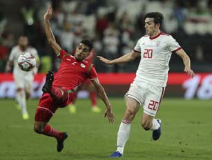 Oman's defender Mohammad Al-Musala (left) fights for the ball with Iran's forward Sardar Azmoun during the AFC Asian Cup round of 16 soccer match between Iran and Oman at Mohammed Bin Zayed Stadium in Abu Dhabi, United Arab Emirates on Sunday.