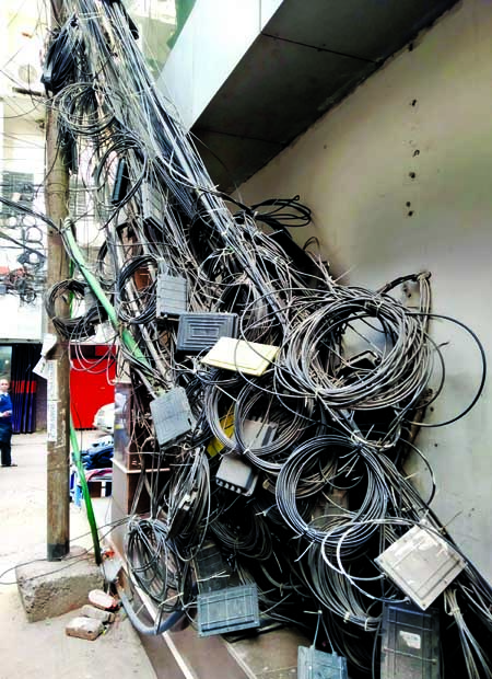 Keeping extra internet cables in open places on the main roads by service providers have become a common phenomenon, causing sufferings to pedestrians. This photo was taken from Motijheel area on Tuesday.