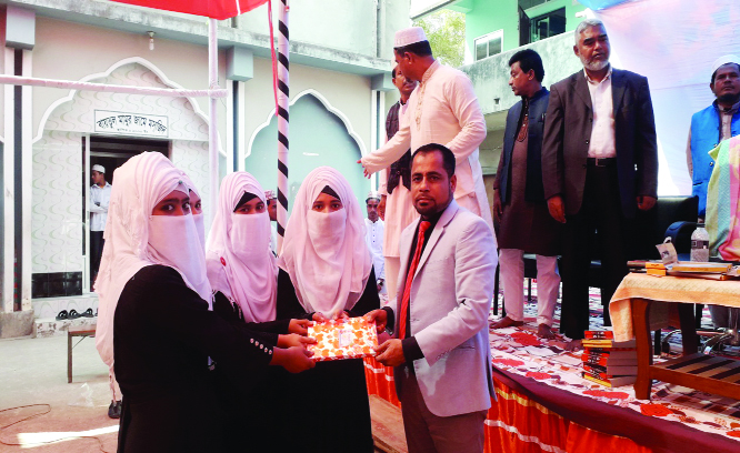 DAMUDYA (Shariatpur): Industrialist Alhaj Khaledur Rahman Sikder, President, Managing Committee of Hamidiya Kamil Madrasa at Damudya Upazila receiving prize from the Kamil examinees at the farewell programme as Chief Guest yesterday.