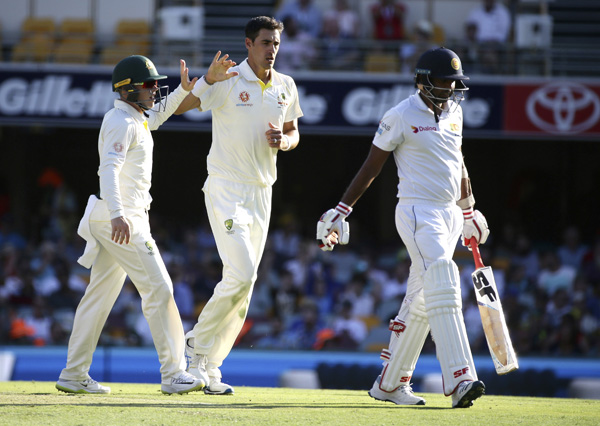 Australia's Mitchell Starc (center) celebrates after he got the wicket of Sri Lanka's Dilruwan Perera (right) during a cricket Test match between Australia and Sri Lanka in Brisbane, Australia on Thursday.