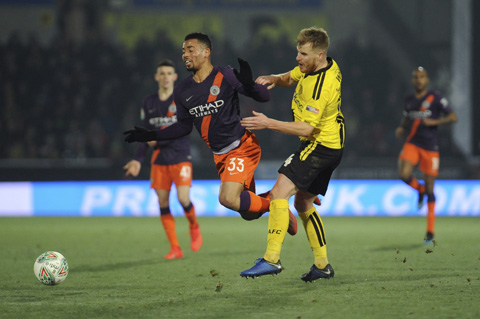 Manchester City's Gabriel Jesus (left) competes for the ball with Burton's Damien McCrory during the English League Cup semifinal soccer match between Burton Albion and Manchester City at Pirelli Stadium in Burton on Trent, England on Wednesday.