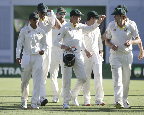 Australia's Marnus Labuschagne (center) walks off with team members Usman Khawaja (left) and Joe Burns (right) after they defeated Sri Lanka during the cricket Test match between Australia and Sri Lanka in Brisbane, Australia on Saturday.