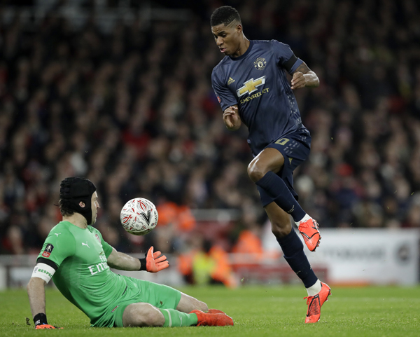 Arsenal goalkeeper Petr Cech (left) makes a save in front of Manchester United's Marcus Rashford during the English FA Cup fourth round soccer match between Arsenal and Manchester United at the Emirates stadium in London on Friday.
