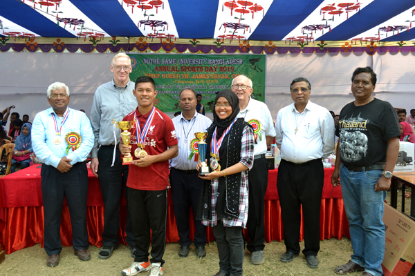 Arnab Hossain Sangma (front left) and Aleya Khatun (front right) the champion of the boys' and girls' event respectively of the Annual Sports Competition of Notre Dame University Bangladesh with the teachers of Notre Dame University Bangladesh pose for