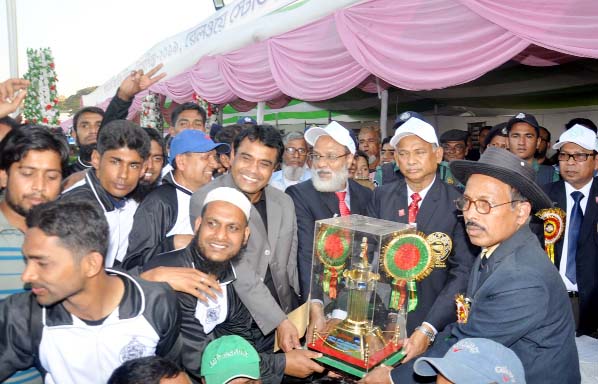 Minister for Railway Nurul Islam Sujan giving trophy to the winning team of annual sports of Chattogram Railway at Railway Polo Ground on Sunday.