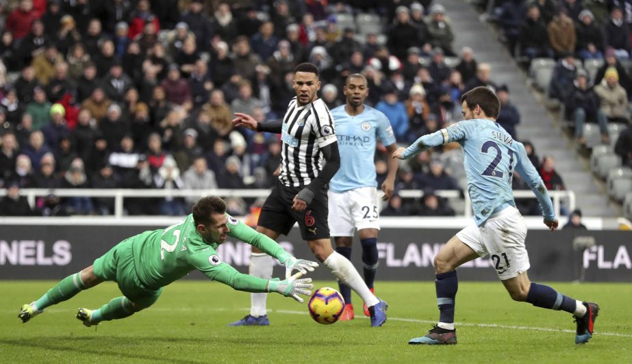 Newcastle United goalkeeper Martin Dubravka (left) and Manchester City's David Silva battle for the ball during their English Premier League soccer match at St James' Park in Newcastle, England on Tuesday.