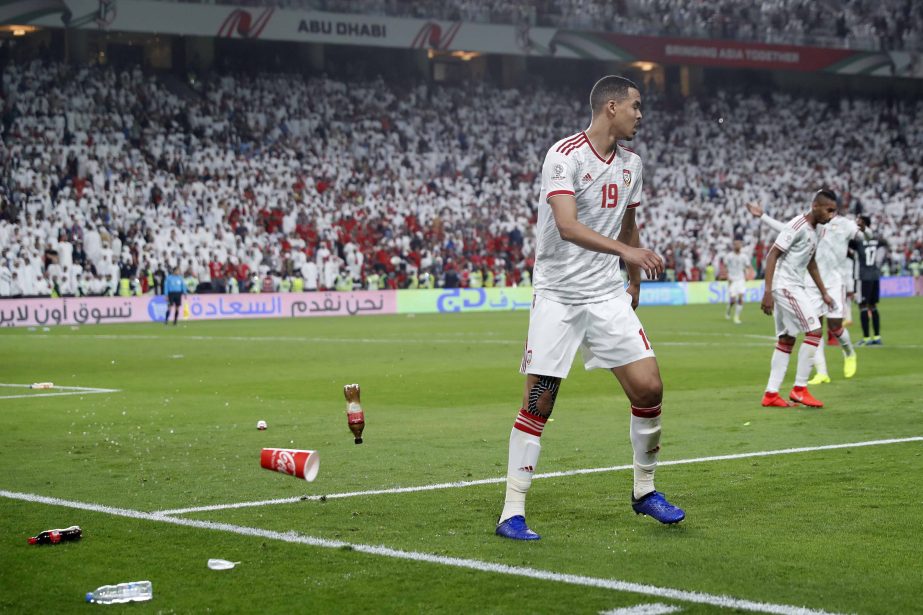 Bottles are thrown on the field by United Arab Emirates fans after Qatar's forward Hasan Al Haydos scores his side's third goal during the AFC Asian Cup semifinal soccer match between United Arab Emirates and Qatar at Mohammed Bin Zayed Stadium in Abu D