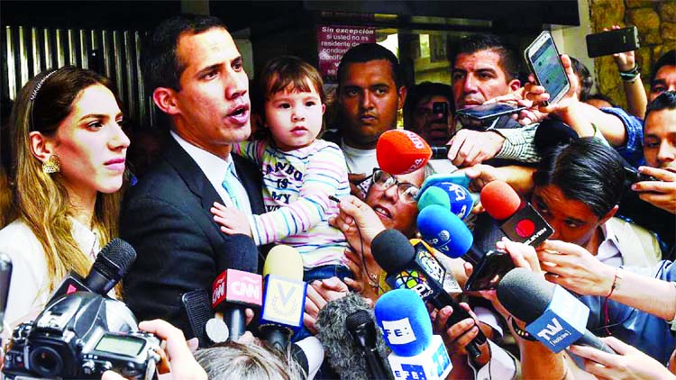Opposition leader and self-proclaimed "acting president" Juan Guaido (2-L) gestures while holding his daughter next to his wife outside their home in Caracas, where he alleged security forces had tried to threaten his family.