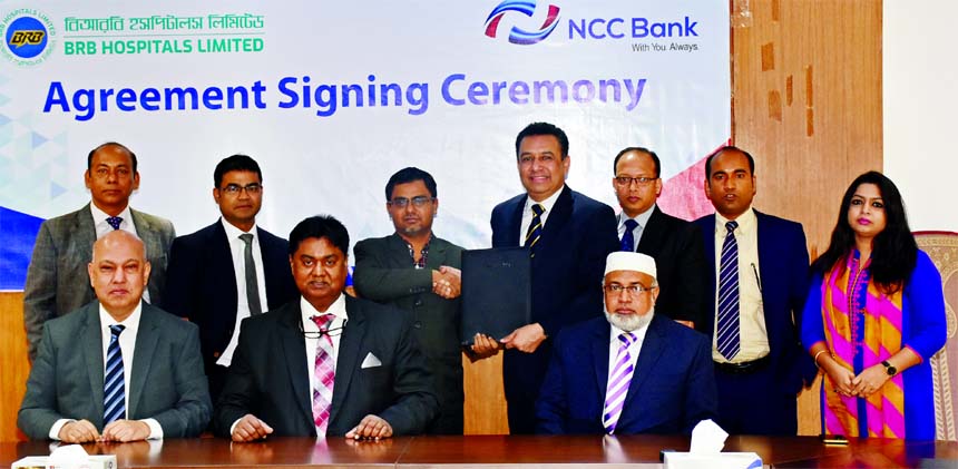 Muhammad H Kafi, Head of Cards of NCC Bank Limited and Md. Mahbub Alam, Chief Financial Officer of BRB Hospitals, poses for a photograph after signing an agreement at the Banks head office in the city on Wednesday. Under the deal, Credit, Debit Cardholder