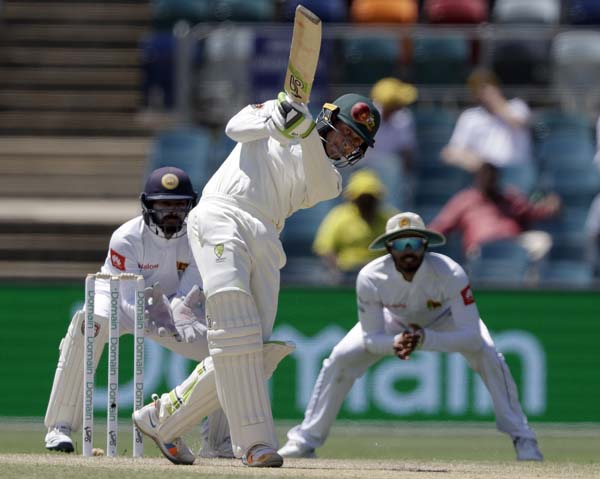 Australia's Usman Khawaja (center) drives the ball against Sri Lanka on day 3 of their cricket Test match in Canberra on Sunday.