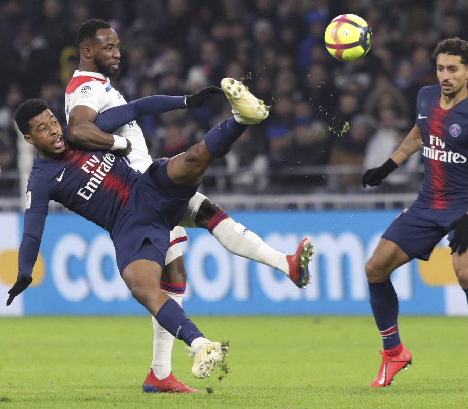 PSG's Presnel Kimpembe (left falling) and Lyon's Moussa Dembele vie for the ball during the French League One soccer match between Lyon and Paris Saint-Germain in Decines, near Lyon, central France on Sunday.