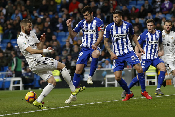 Real Madrid's Karim Benzema (left) tries to control the ball next to Deportivo Alaves' Manu Garcia (center) and Guillermo Maripan during a La Liga soccer match between Real Madrid and Deportivo Alaves at the Bernabeu stadium in Madrid, Spain on Sunday.