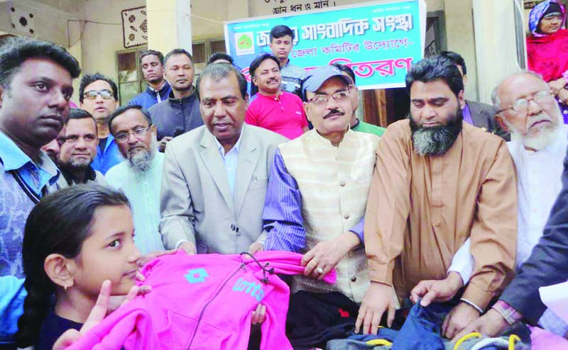 DUPCHANCHIA(Bogura): Rezaul Karim Badsha, Editor, the Daily Bogura News distributing over jackets among the students marking the 37th founding anniversary of Jatiya Sangbadik Sangstha at Sadar Upazila on Sunday.