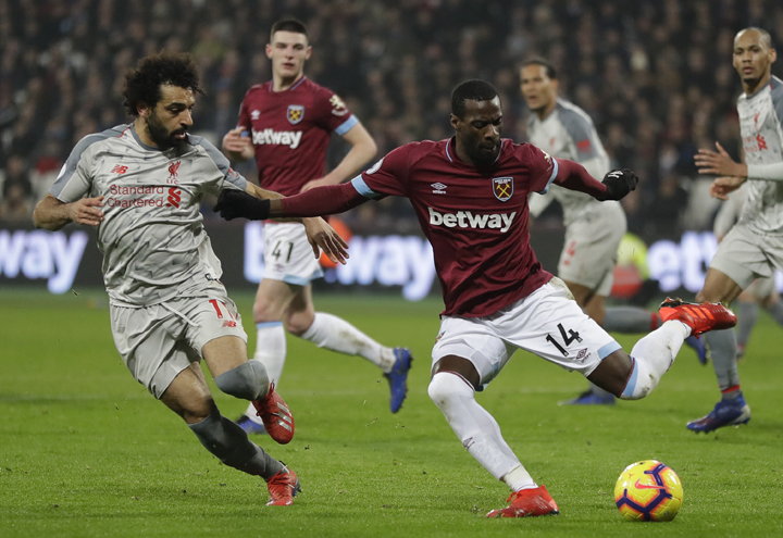 Liverpool's Mohamed Salah (left) and West Ham's Pedro Obiang challenge for the ball during the English Premier League soccer match between West Ham United and Liverpool at the London Stadium in London on Monday.