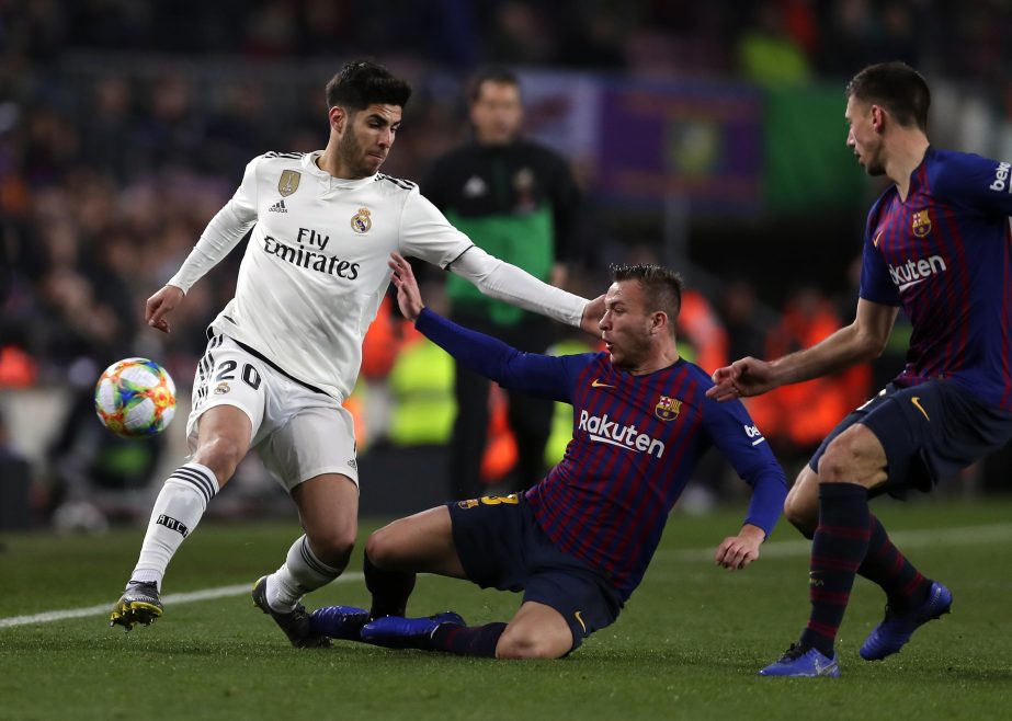 Real midfielder Marco Asensio (left) duels for the ball with Barcelona midfielder Arthur during the Copa del Rey semifinal first leg soccer match between FC Barcelona and Real Madrid at the Camp Nou stadium in Barcelona, Spain on Wednesday.