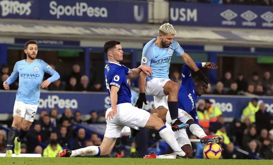 Manchester City's Sergio Aguero battles for the ball with Everton's Idrissa Gueye (left) and Michael Keane during their English Premier League soccer match at Goodison Park, Liverpool, England on Wednesday.