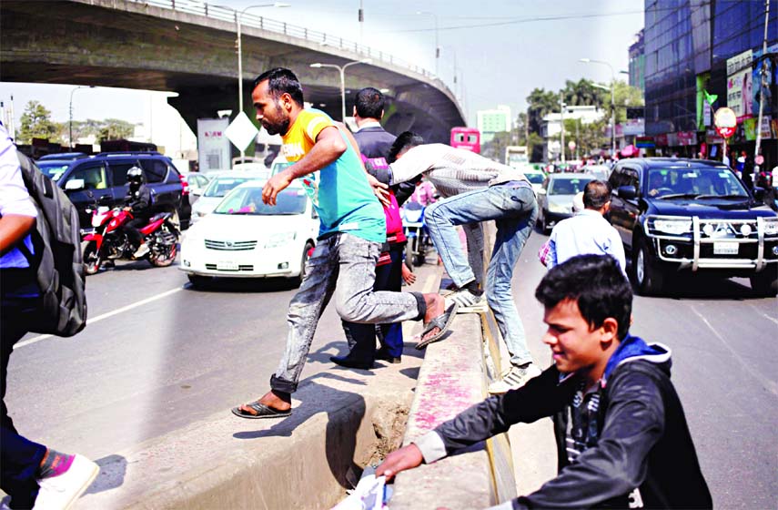 Common phenomena in city : Taking risk of life pedestrians crossing the busy road stopping the running vehicles and defying traffic rules. This photo was taken from underneath the Mohakhali Flyover on Saturday.