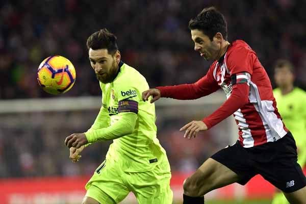 FC Barcelona's Lionel Messi (left) duels for the ball beside Athletic Bilbao's Markel Susaeta during the Spanish La Liga soccer match between Athletic Bilbao and FC Barcelona at San Mames stadium, in Bilbao, northern Spain on Sunday.