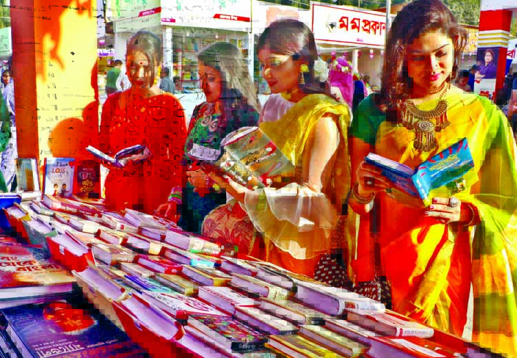 Visitors flip through the books at a stall of Amar Ekushey Book Fair on Bangla Academy premises in the city on Wednesday marking 'Pahela Falgoon'.