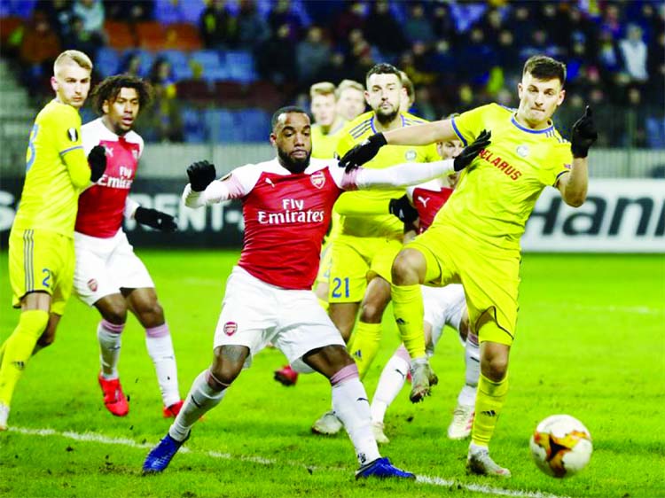 Arsenal's Alexandre Lacazette (front center) duels for the ball with Bate's Stanislav Dragun during the Europa League round of 32 first leg soccer match between Bate and Arsenal at the Borisov-Arena in Borisov, Belarus on Thursday.