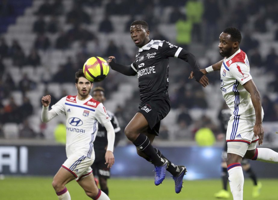 Guingamp's Cheik Traore (center) duels for the ball with Lyon's Moussa Dembele, right, during the French League One soccer match between Lyon and Guingamp at the Stade de Lyon near Lyon, France on Friday.