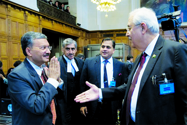 Pakistan's attorney general Anwar Mansoor Khan, (right), greets Deepak Mittal, the joint secretary of India's Foreign Ministry, as he presents oral arguments at the International Court of Justice, or World Court, in The Hague, Netherlands on Monday.