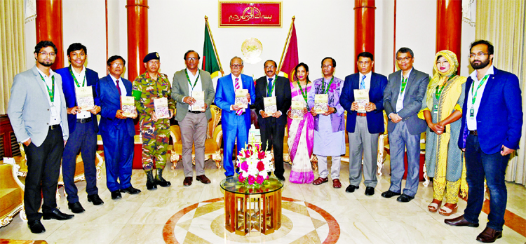 President Abdul Hamid along with other distinguished persons holds the copies of a book titled 'Mourja' written by litterateur Abul Kashem at the book handing over ceremony to President at the Bangabhaban on Tuesday.
