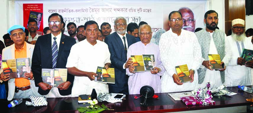 BNP Standing Committee Member Dr. Khondkar Mosharraf Hossain along with others holds the copies of two books titled 'Mithyar Kache Jati Parajita and Nishiratrir Diprahar' written by Advocate Taimur Alam Khondkar at its cover unwrapping ceremony at the J